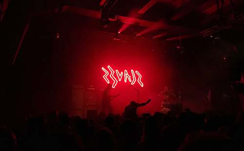 night life Slaves lighted signage on stage crowd